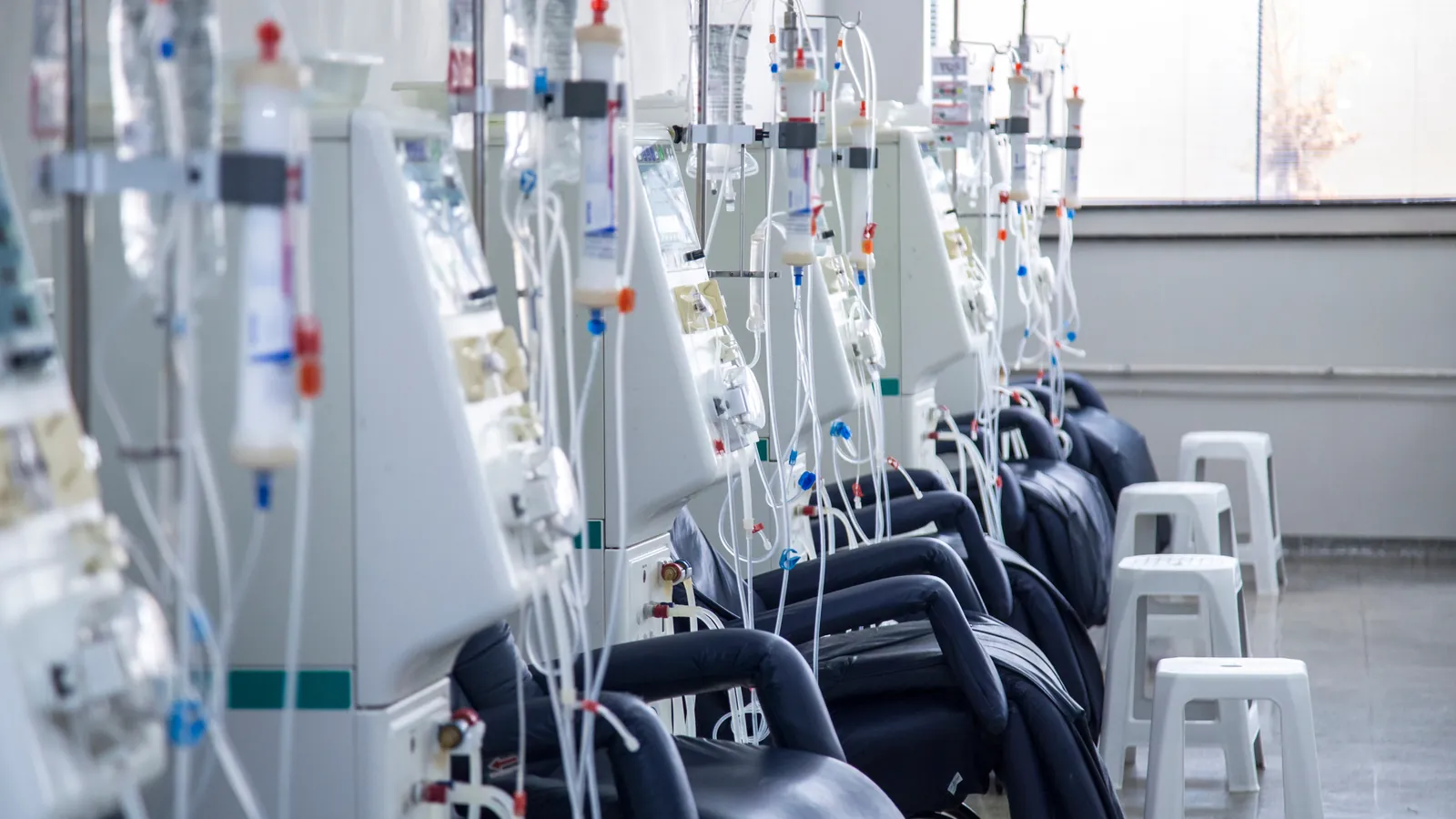 Hemodialysis machines beside empty treatment chairs.